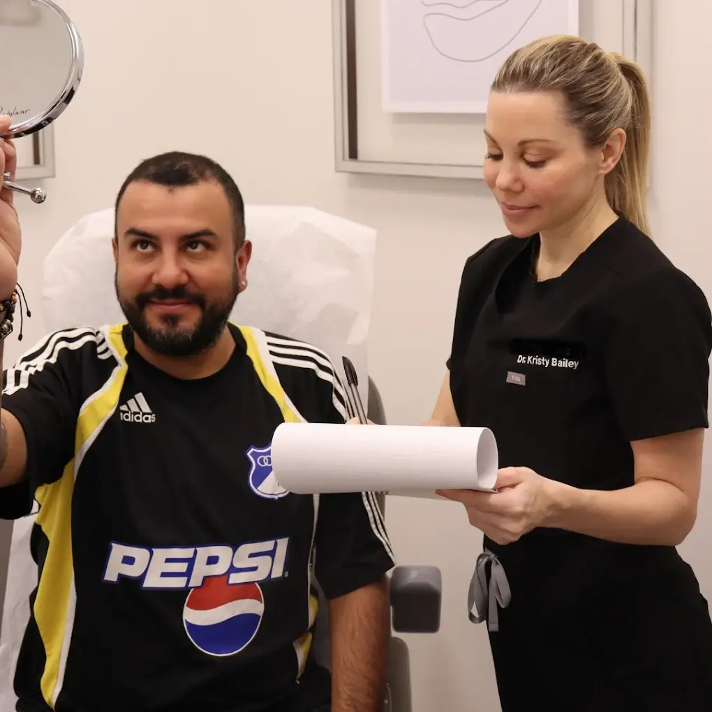 man examining hair transplant progress with doctor