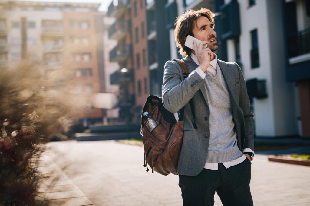 man confidently walking on street on the phone